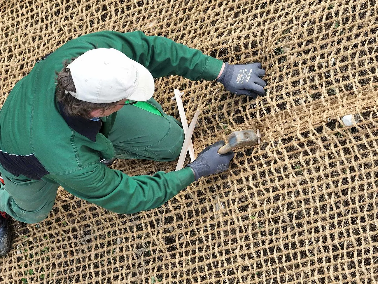 © Felbermayr/Nusime Arbeiter beim Anbringen von Kokosgewebe durch Einsatz eines Hammers